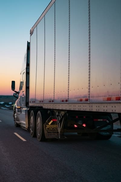 truck trailer driving at night with a white trailer
