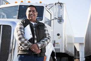 owner operator standing next to his white truck