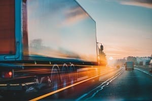tractor trailer driving into the sunset
