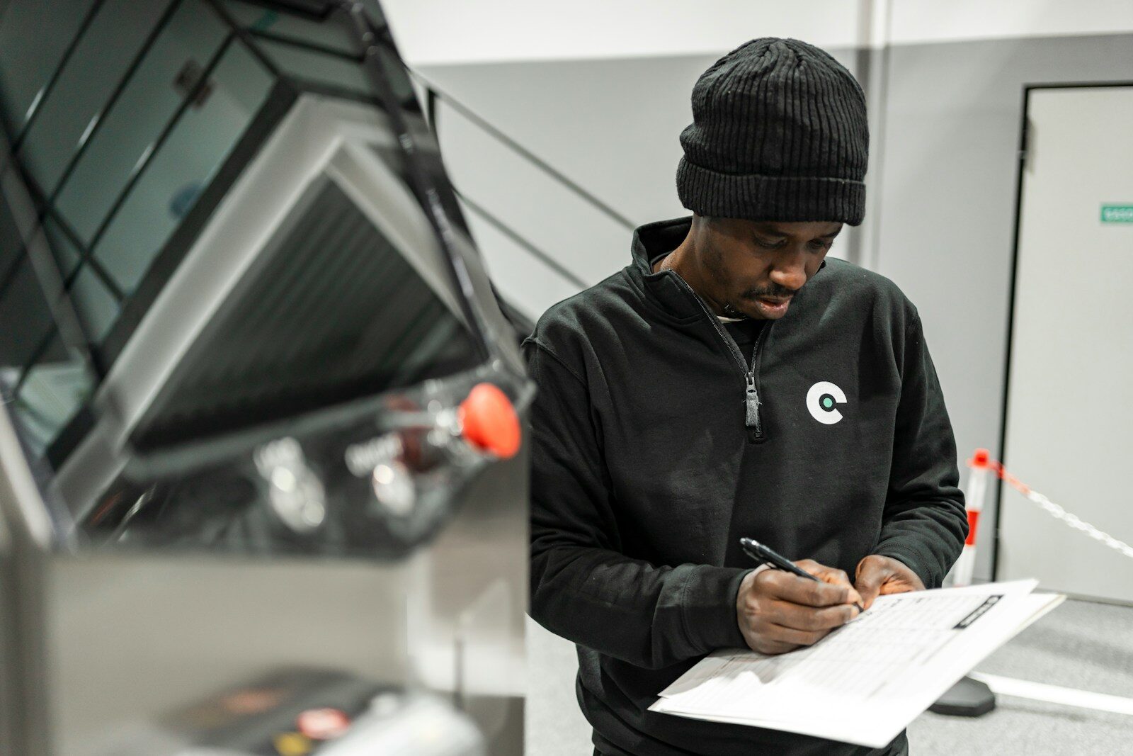 A man is writing by a car.